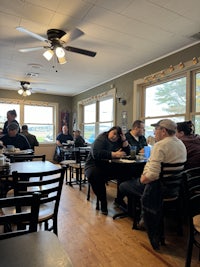 a group of people sitting at tables in a restaurant