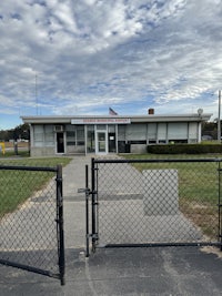 the front of a building with a chain link fence