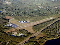 an aerial view of an airport in a wooded area