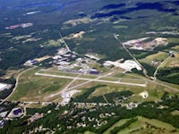 an aerial view of an airport in a wooded area