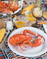 a plate of lobster and corn on a table