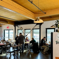 a group of people are sitting at tables in a restaurant