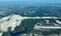 an aerial view of an airport near a lake