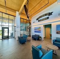a lobby with blue chairs and large windows
