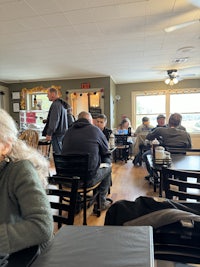 a group of people sitting at tables in a restaurant