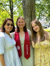 three women posing for a photo in front of a tree