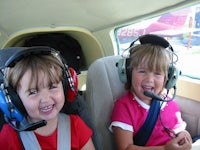two young girls in a plane wearing headsets