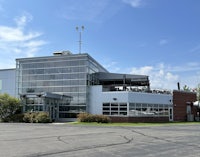 a large building with a glass roof and a parking lot