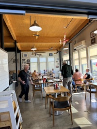 a group of people sitting at tables in a restaurant