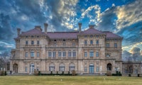 an ornate mansion sits on top of a grassy field
